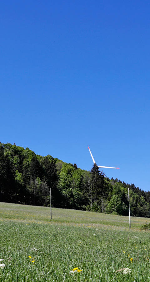 Sur les crêtes du Jura, des éoliennes majestueuses se dressent vers le ciel